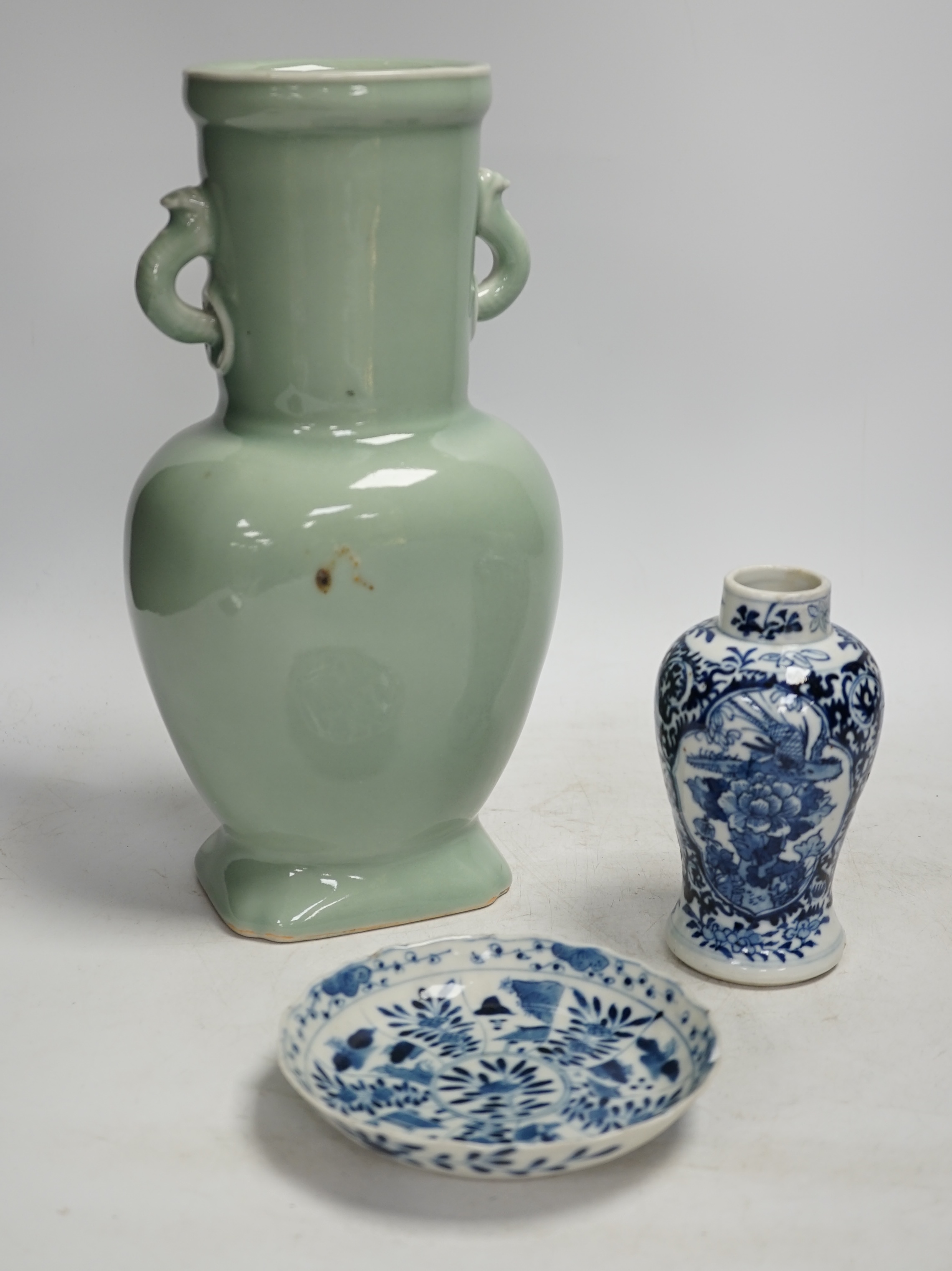 A Chinese celadon glazed two handled vase and a Chinese blue and white vase and dish, celadon vase 28.5cm high. Condition - celadon vase has a firing flaw and large crack, both blue and white vase are in damaged conditio